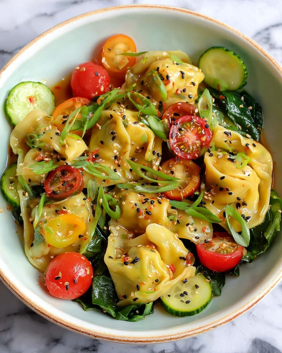 The dish is served in a white bowl and features three main layers: the bottom layer is fresh leafy greens in dark green; the middle layer consists of yellow dumplings with a soft, glossy texture, folded and slightly curled; the top layer includes round slices of cucumber in light green with dark green edges, halved red and yellow cherry tomatoes, and small green scallions scattered throughout. Black sesame seeds are sprinkled on all layers, adding small contrasting dots. The whole dish has a light glaze of sauce giving it a shiny, slightly oily look. It sits on a white marbled surface. photo taken with an iphone --ar 4:5 --v 7