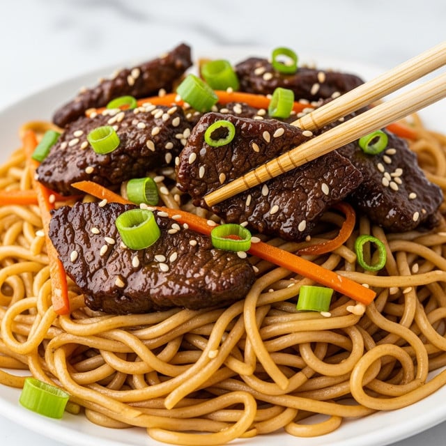 A close-up image showing a dish with three main layers: at the bottom, thin yellow noodles with a slightly glossy texture; on top of the noodles, pieces of brown, juicy, cooked beef coated in a shiny, dark sauce; scattered over the beef and noodles are small, bright orange carrot sticks and fresh green onion slices, with white sesame seeds sprinkled on the beef pieces. Wooden chopsticks held by a woman's hand are picking up a piece of beef. The whole dish is placed on a white plate against a white marbled texture background. photo taken with an iphone --ar 4:5 --v 7