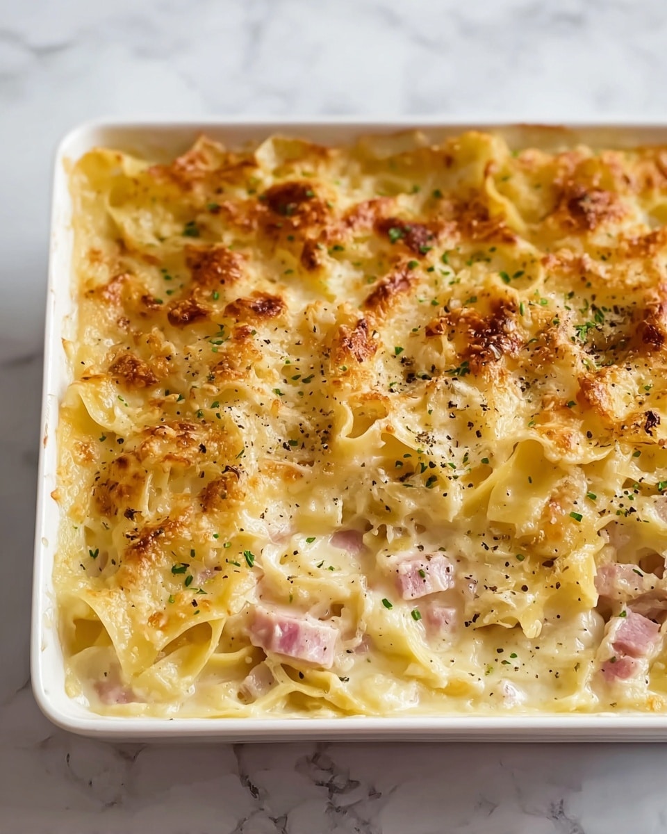 The image shows a close-up of a cooked meatloaf with a golden brown crust on top, featuring a slightly shiny, caramelized texture. The surface has a mix of melted cheese and herbs scattered all over, adding small green and white flecks. The inside of the meatloaf visible along the sides is lighter brown with a moist and soft texture dotted with small herbs. The meatloaf sits on a black surface with a few out-of-focus leafy greens near the edges. Photo taken with an iphone --ar 4:5 --v 7
