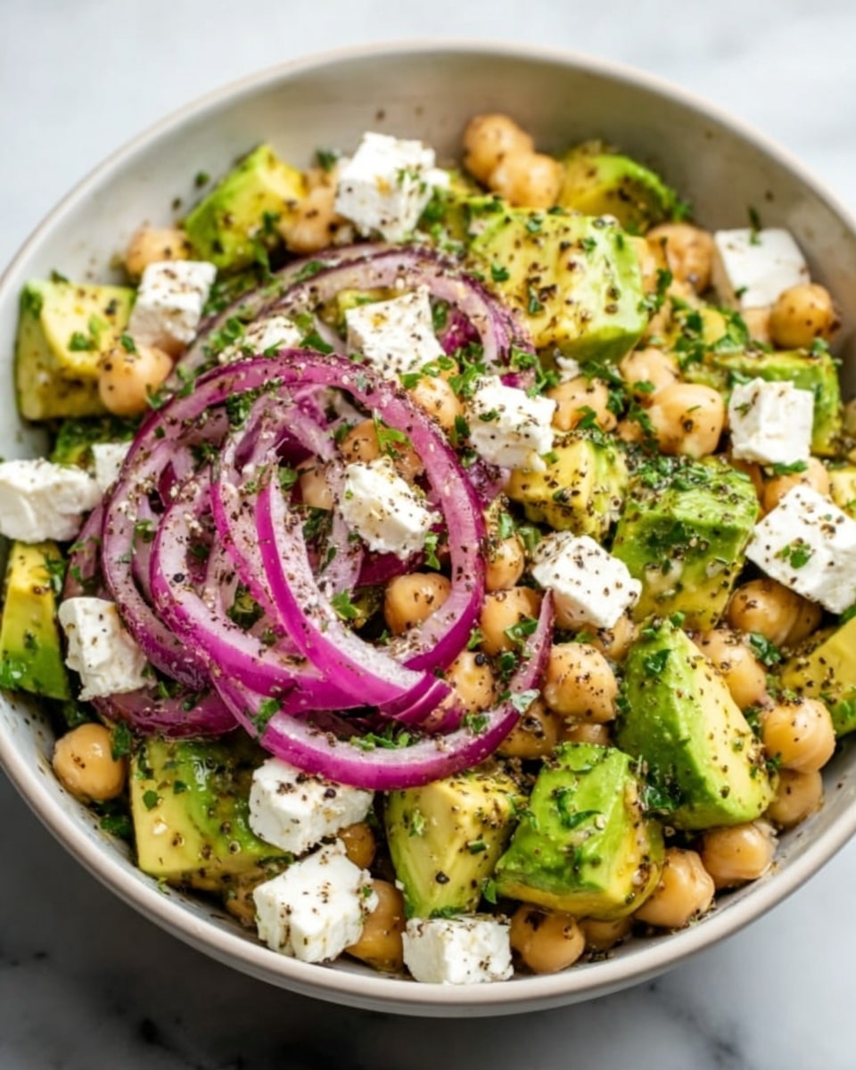 A bowl of ramen with a creamy, light brown broth fills the base. On top, there are five slices of grilled chicken with a golden, slightly charred outer layer arranged in a fan shape on one side. Near the chicken is a soft-boiled egg cut in half, showing a bright orange yolk and white edges. In the center, a generous pile of chopped green onions adds a fresh green color, sprinkled with red chili flakes. Curly yellow noodles are placed on the right side with chopsticks lifting some from the bowl. A small mound of more red chili powder sits near the noodles. The bowl is white and sits on a white marbled surface. photo taken with an iphone --ar 4:5 --v 7